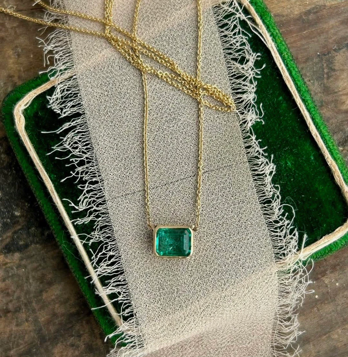 Emerald necklace draped on vintage velvet box